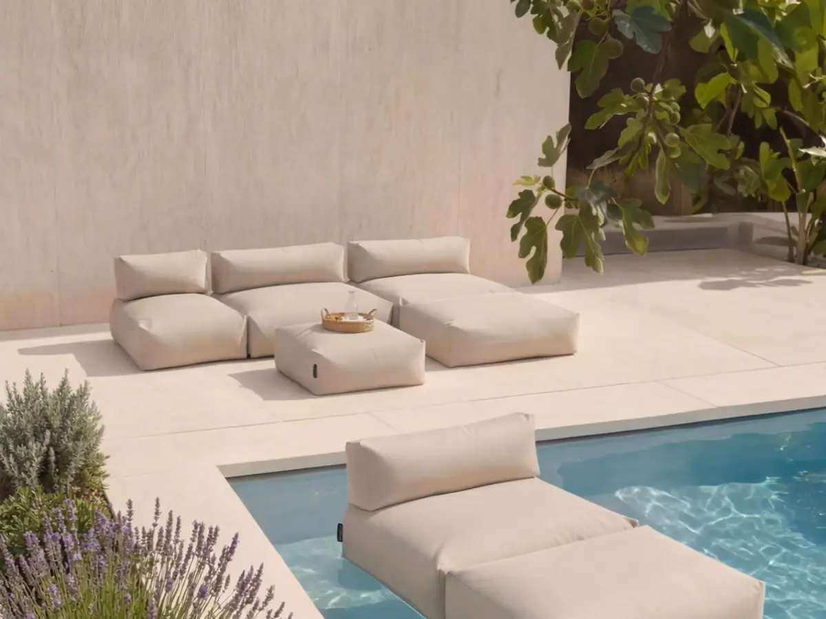 Poolsofa Pool mit weißen Kissen und einem Tisch.