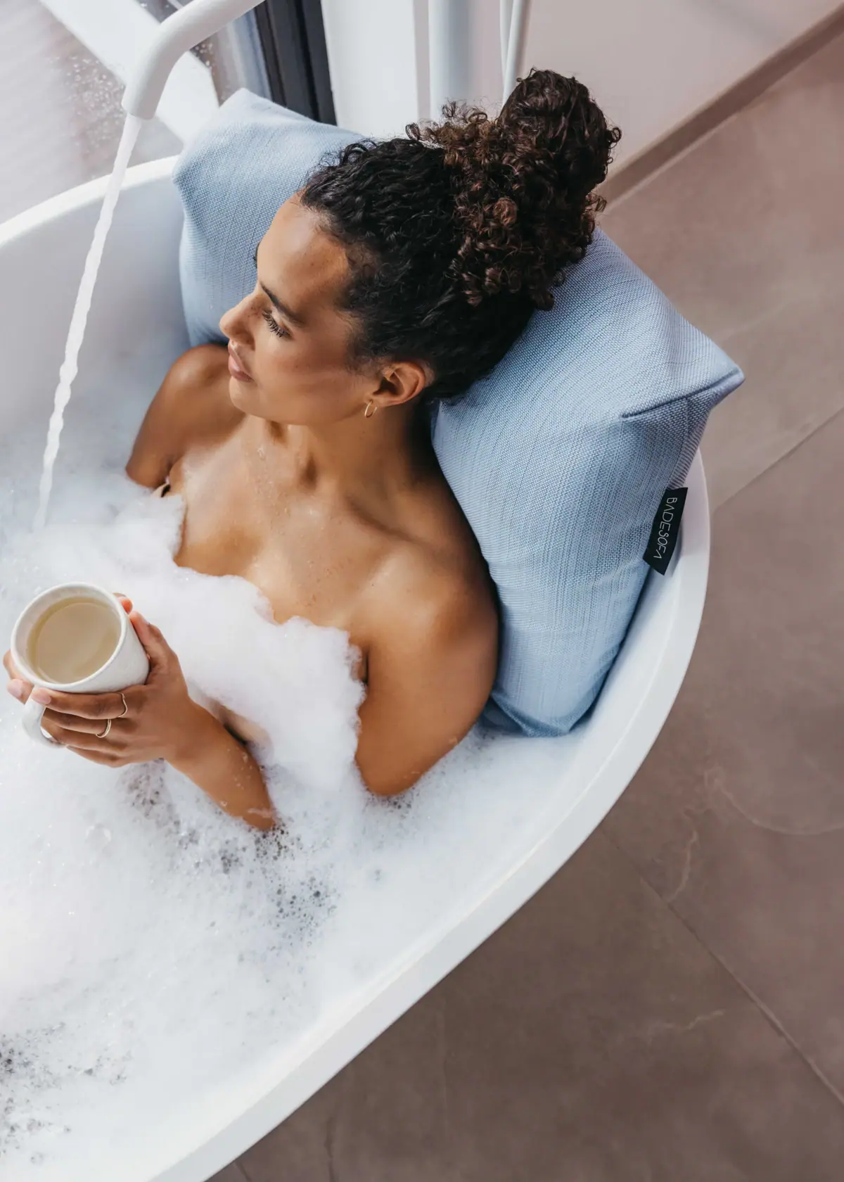 Badesofa Eine Frau in einer Badewanne mit Schaum.