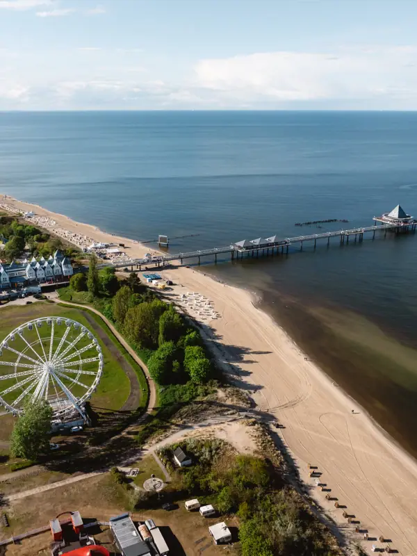 Heringsdorf Strand mit einem Pier und einem Riesenrad im Hintergrund.