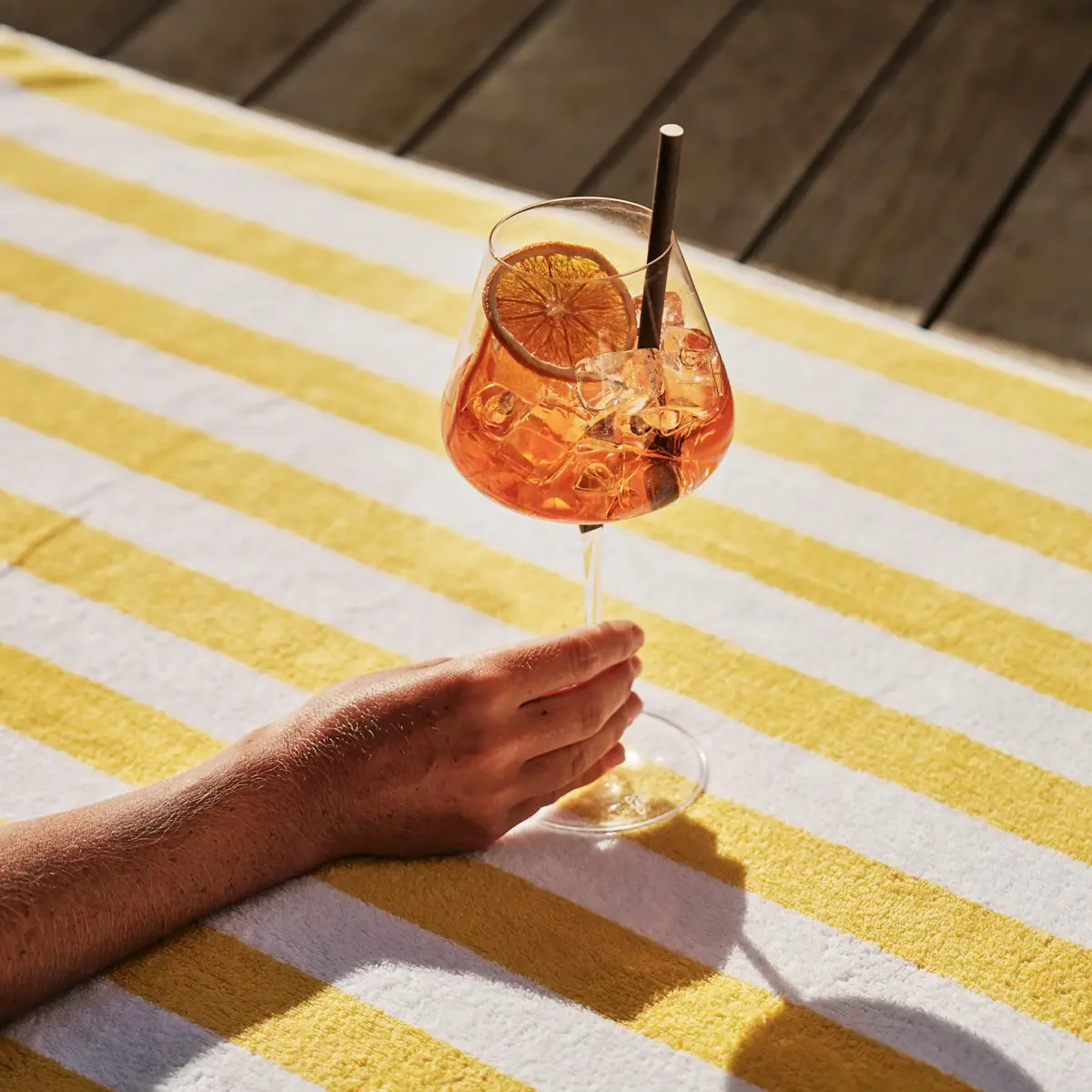 Aperol Spritz Eine Hand hält ein Glas Aperol Spritz.