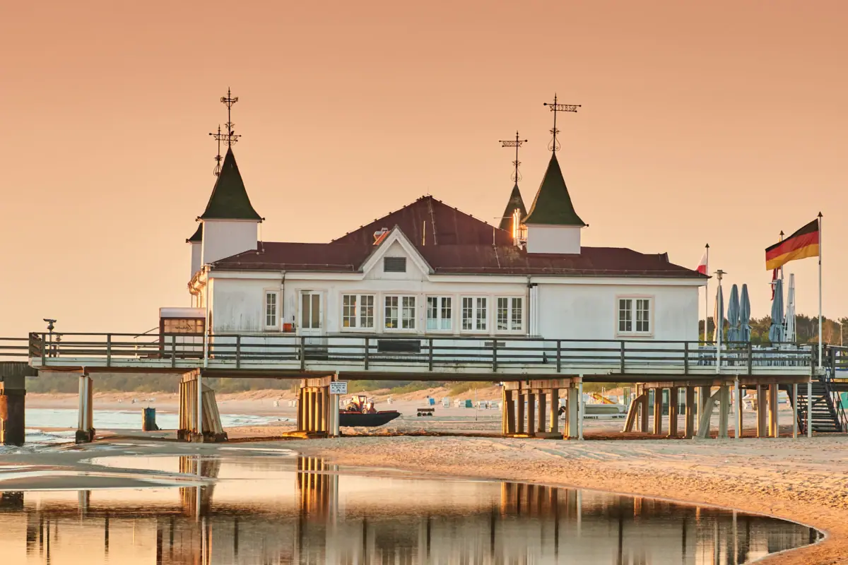 Kaiserbad Ein Gebäude am Strand von Usedom mit Blick auf das Wasser und den Himmel.