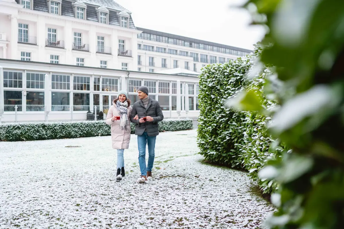 Eine Frau und ein Mann vor einem historischen Gebäude in einer Winterlandschaft
