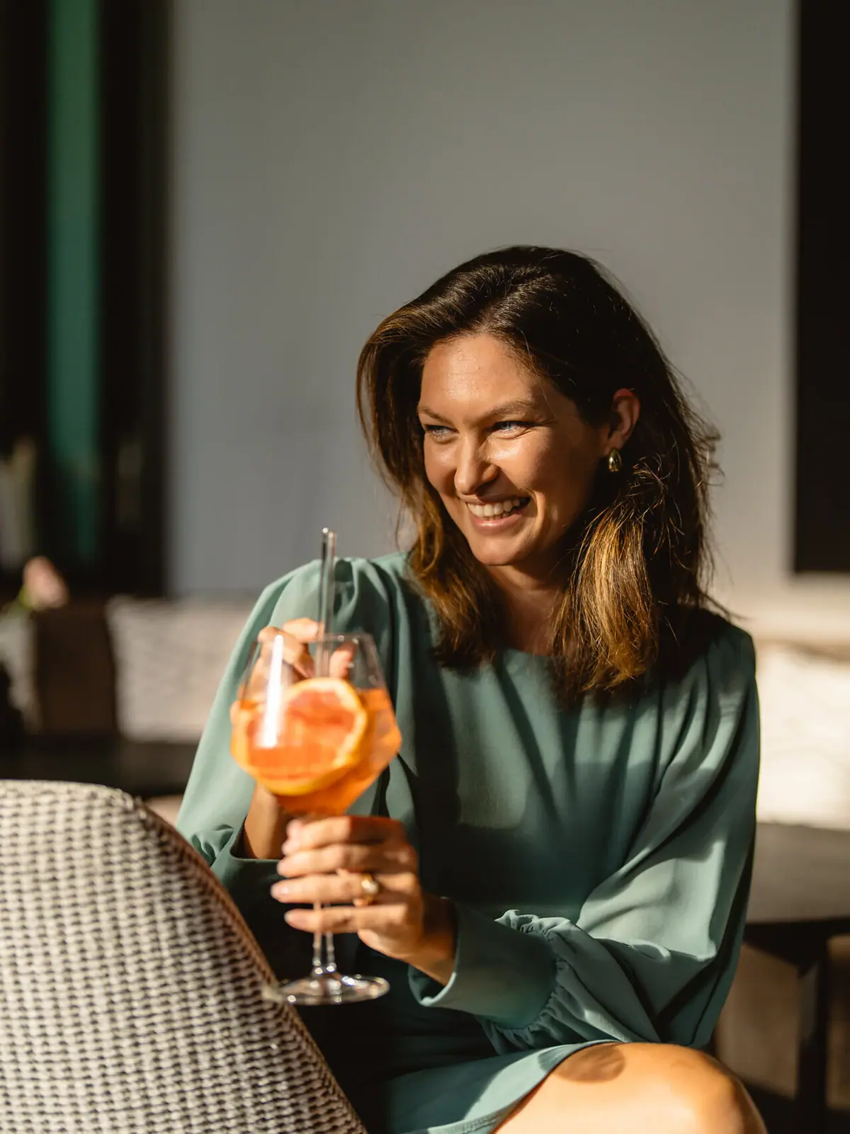 Frau trinkt Aperol Eine lächelnde Frau hält ein Getränk.