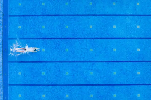 Außenpool im A-ROSA Travemünde Eine Person schwimmt in einem Pool.