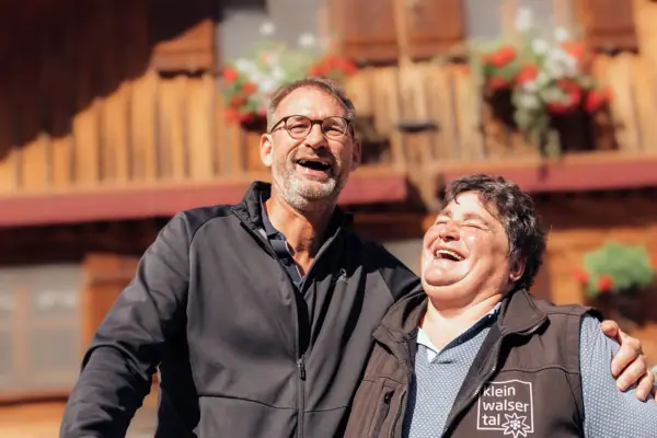 Bärgunthütte Kleinwalsertal Zwei Menschen stehen vor der Bärgunthütte im Kleinwalsertal und lachen.