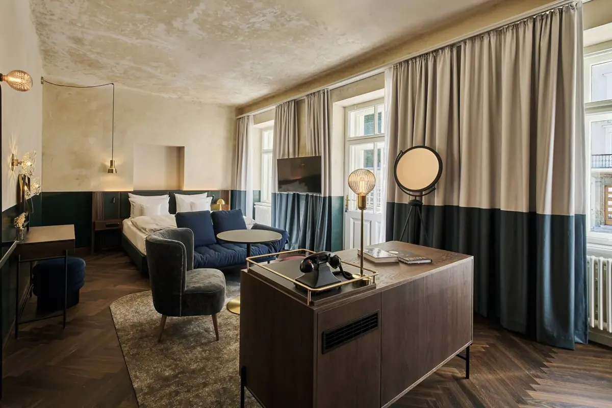 Juniorsuite im A-ROSA Straubinger Grand Hotel Bad Gastein Ein Zimmer mit einem Bett und einem Sofa.