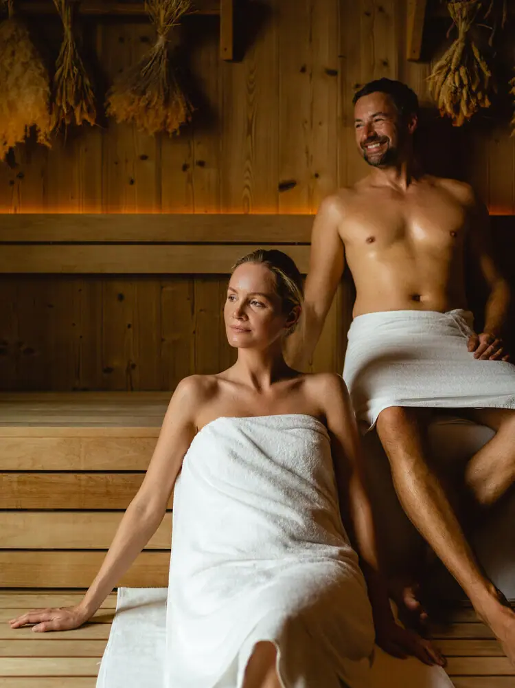 Sauna im SPA-ROSA Sylt Ein Mann und eine Frau in einer Sauna.