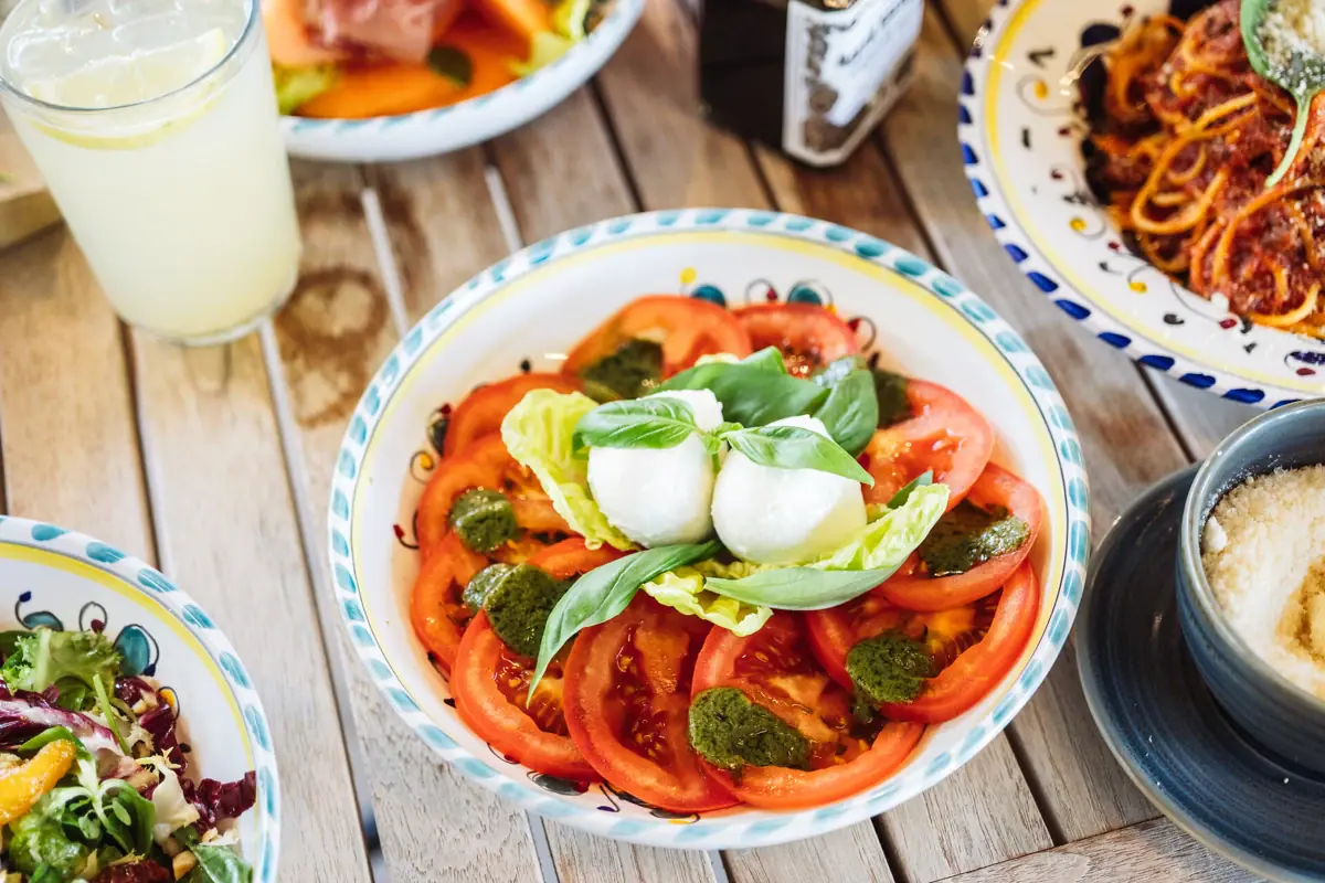 Tomatensalat Eine Schüssel mit Tomaten und Basilikum auf einem Tisch.