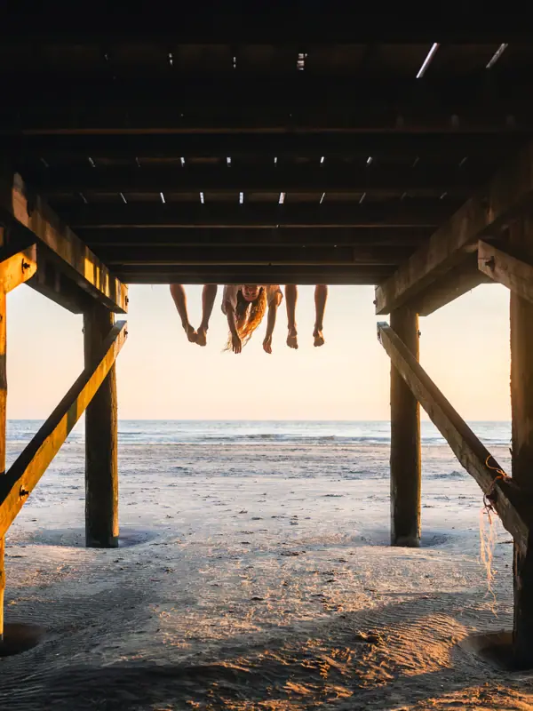 St. Peter Ording Eine Gruppe von Menschen auf einem hölzernen Bauwerk am Strand von St. Peter-Ording.