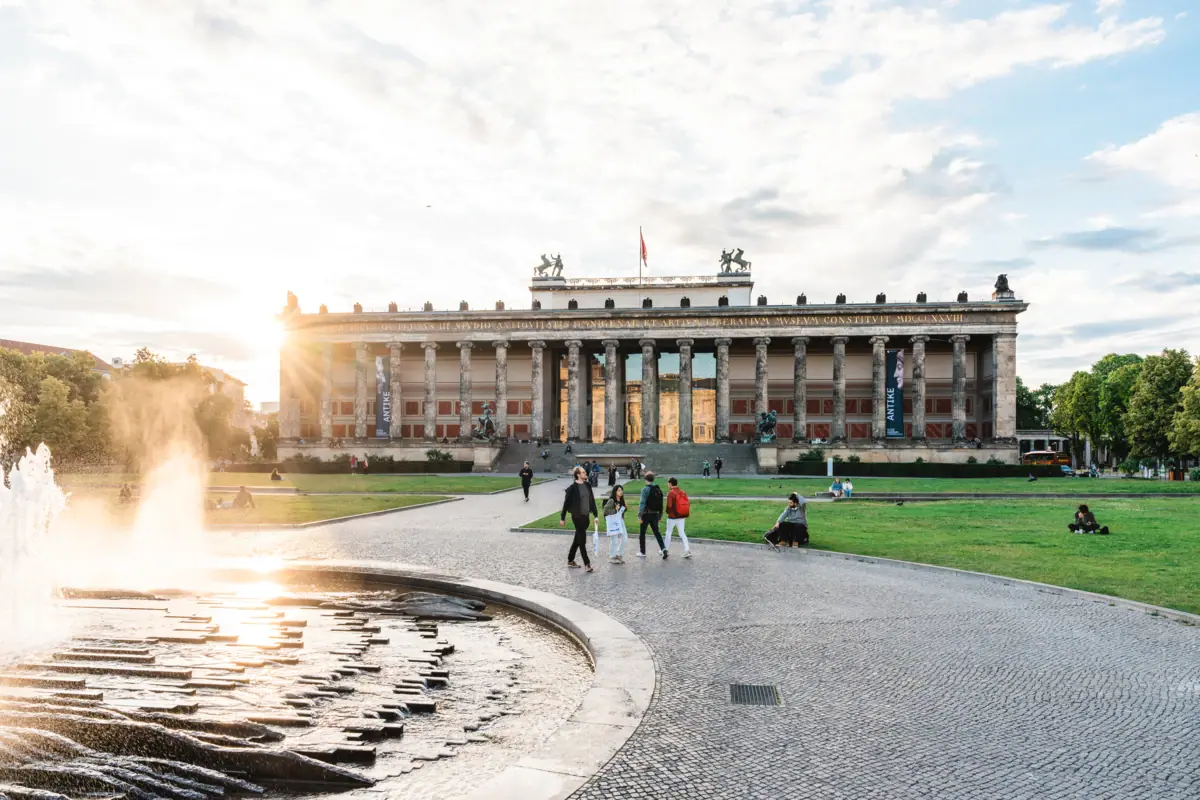Berlin Museum Ein Brunnen im Vordergrund mit einem Gebäude im Hintergrund.