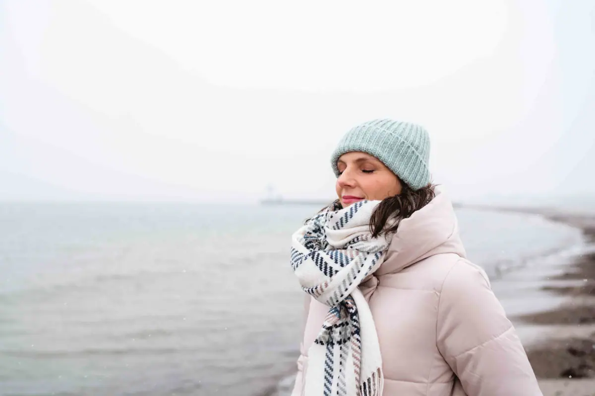 Frau in Winterkleidung am Meer