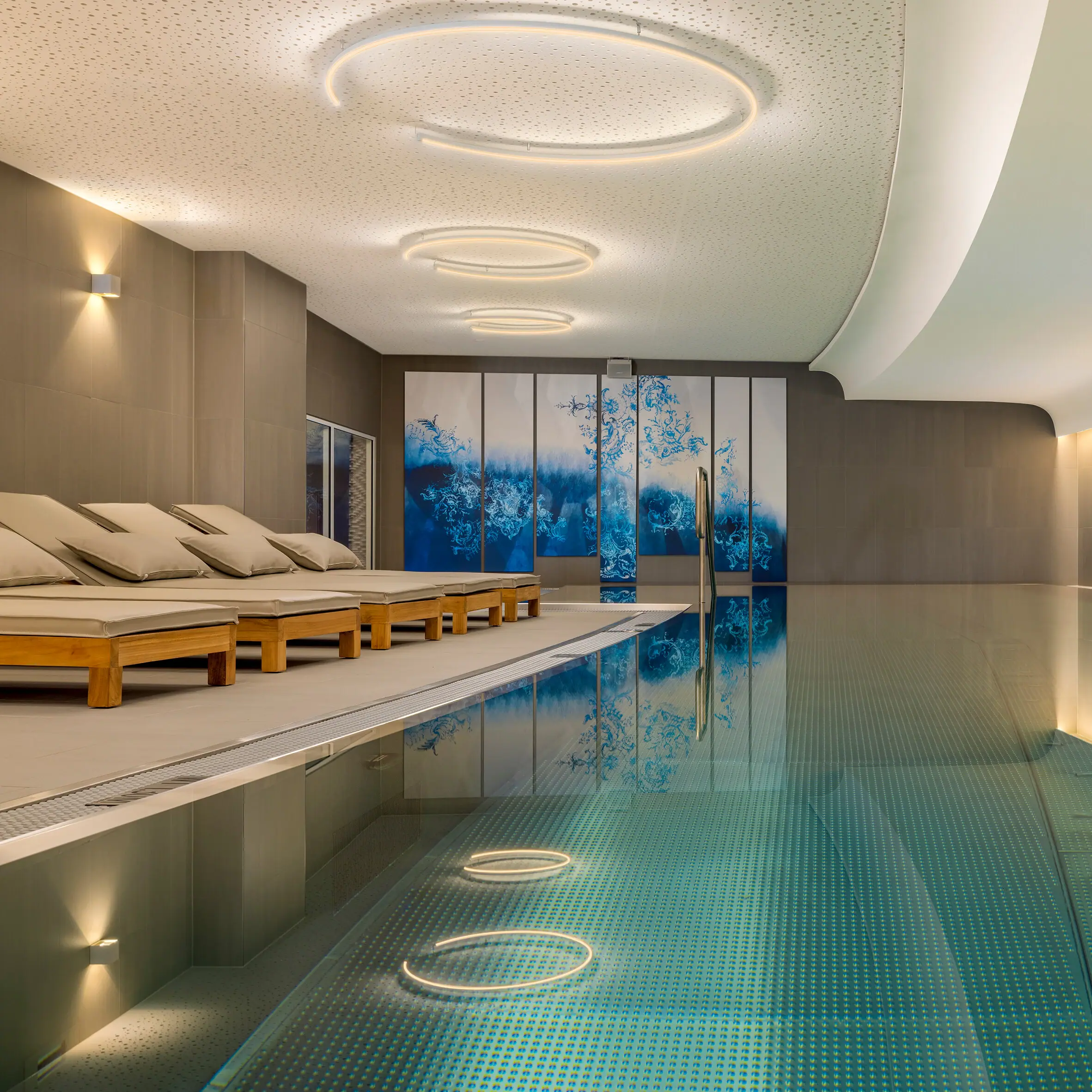 Wellness A-ROSA Tegernsee Der Wellnessbereich im A-ROSA tegernsee mit einem Indoorpool und Liegen.