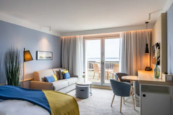 Zimmer im A-ROSA Travemünde Ein Zimmer mit einem Bett und einem Sofa.