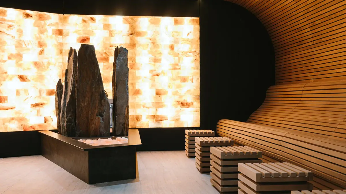 Sauna im SPA-ROSA Gardasee Eine Sauna mit einer großen Salzskulptur und Bänken.