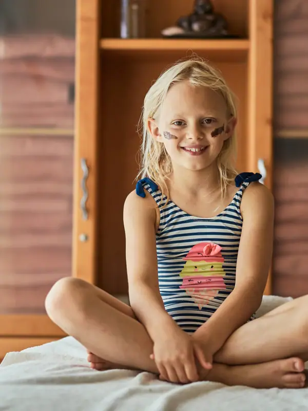 Kindermassage im aja Bansin Mädchen sitzt auf einer Liege.