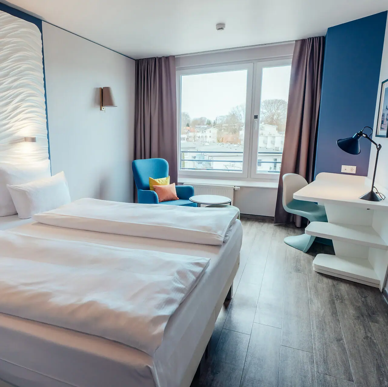 Zimmer im aja Grömitz Ein Zimmer mit zwei Betten und einem Tisch.