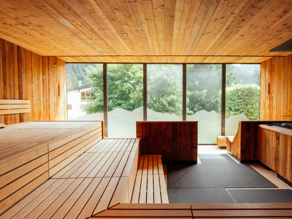 Panoramasauna A-ROSA Ifen Hotel Kleinwalsertal Ein Raum mit Holzbänken und Fenstern.