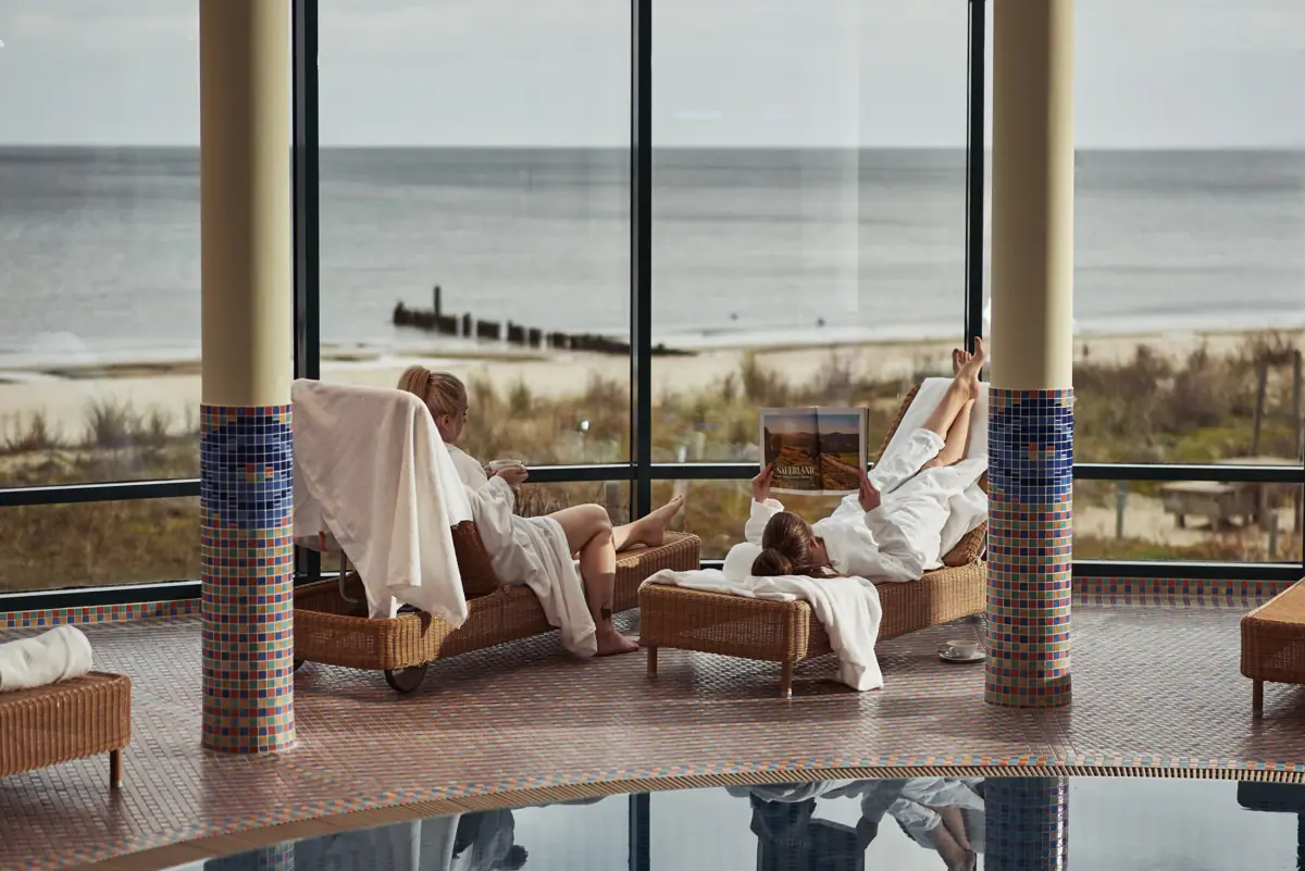 SPA Bereich im aja Zwei Menschen liegen im SPA Bereich im aja Bansin mit Blick auf die Ostsee.