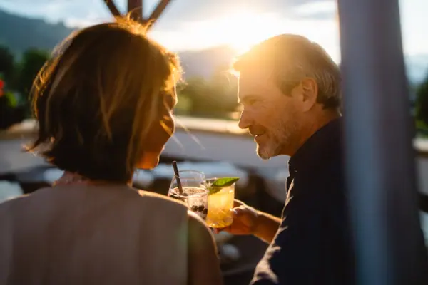 Bar Terrasse Ein Mann und eine Frau halten Getränke auf einer Terrasse.