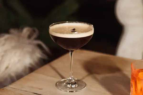 Espresso Martini Ein Glas mit einem Getränk auf einem Tisch.