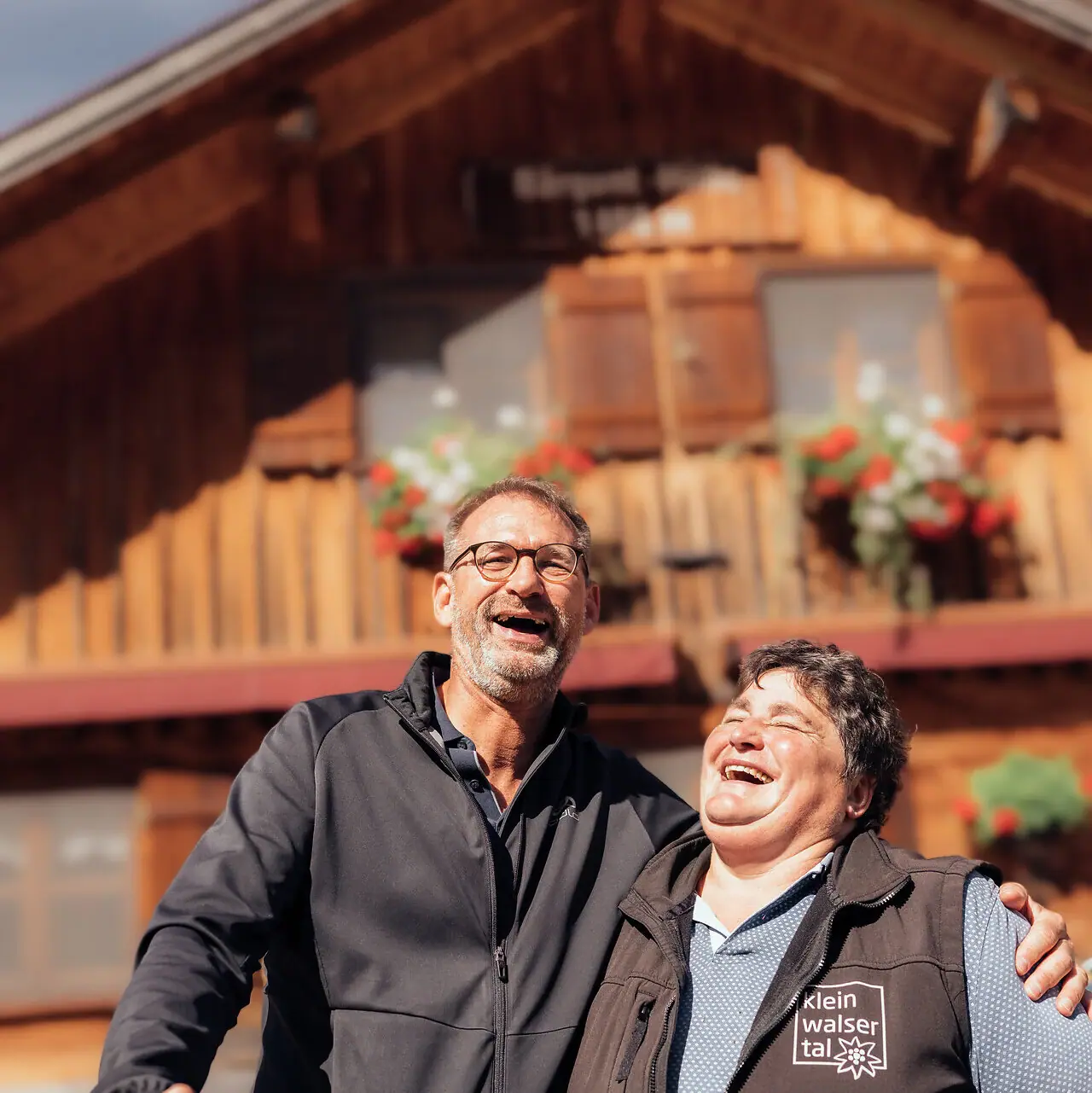 Menschen & Geschichten Ein Mann und eine Frau stehen vor einem Haus.
