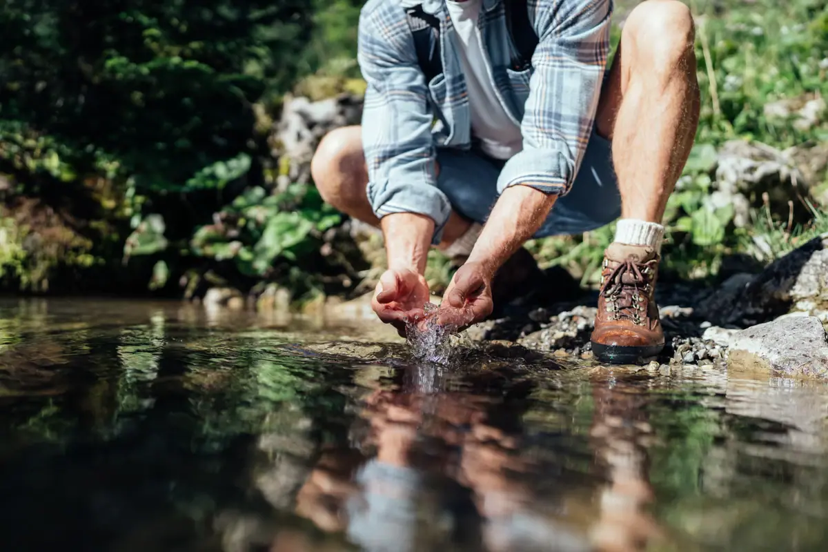 Gebirgsflüsschen im Bärgunttal Ein Mann hockt in einem Wasserstrom.