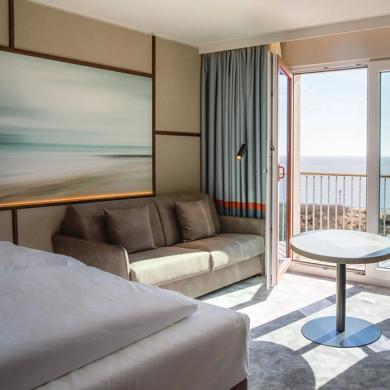 Zimmer im A-ROSA Sylt Ein Zimmer mit einem Bett, einer Couch und einem Tisch.