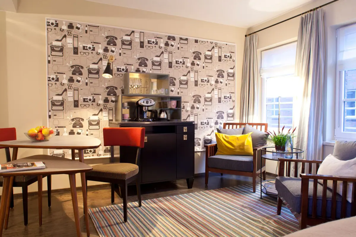 Zimmer im HENRI Hamburg Ein Raum mit einer Kaffeemaschine und Stühlen.