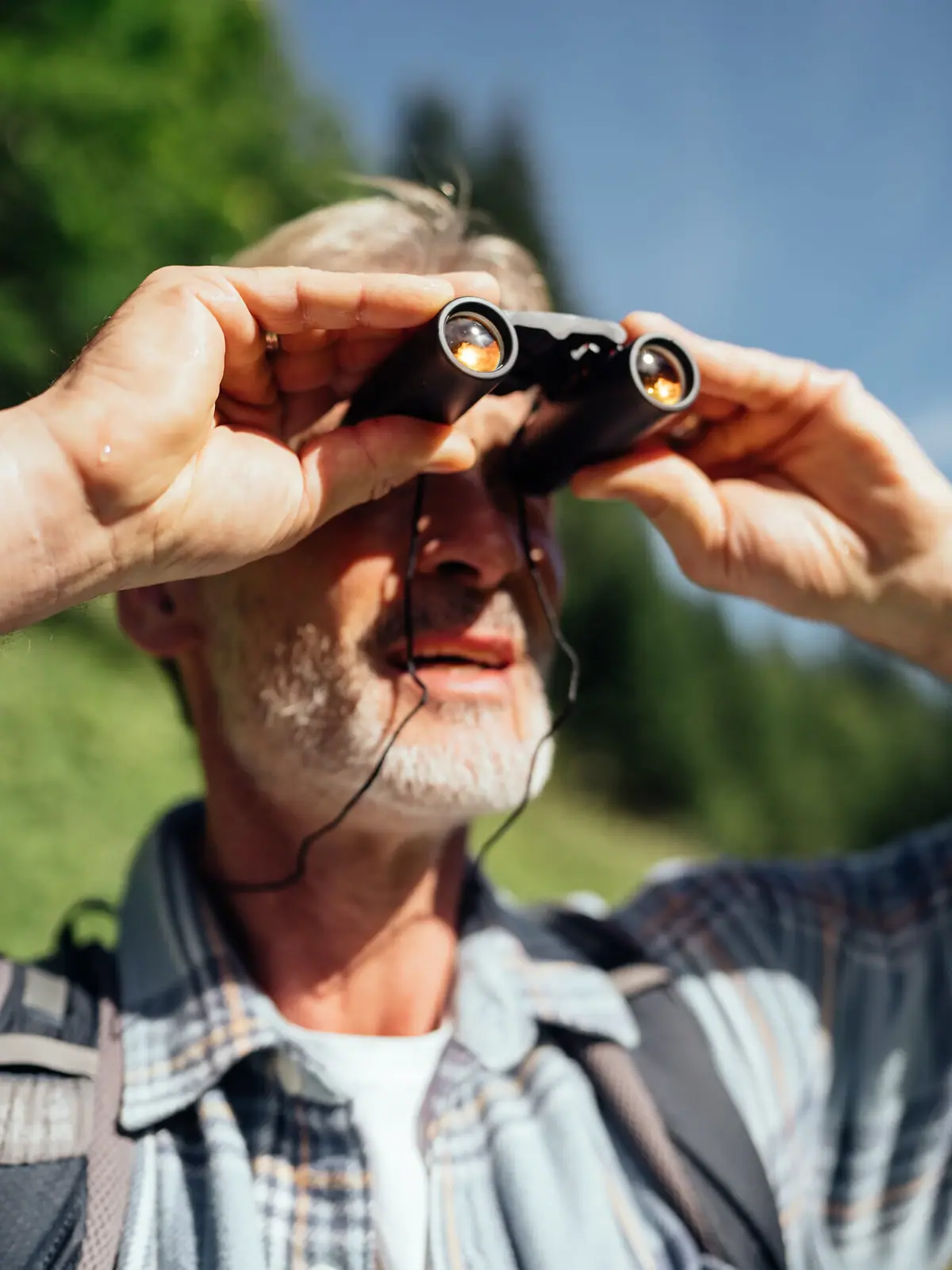 Ziegenbeobachtung im Bärgunttal Ein Mann schaut durch ein Fernglas im Bärgunttal.