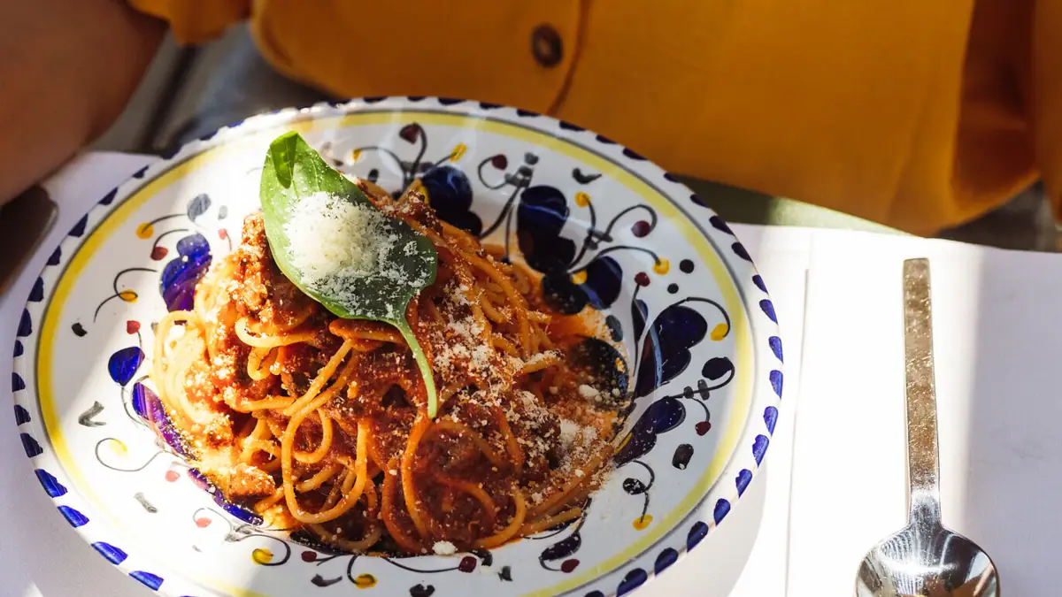 Pasta Ein Teller mit Pasta, einer Gabel und einem Löffel.