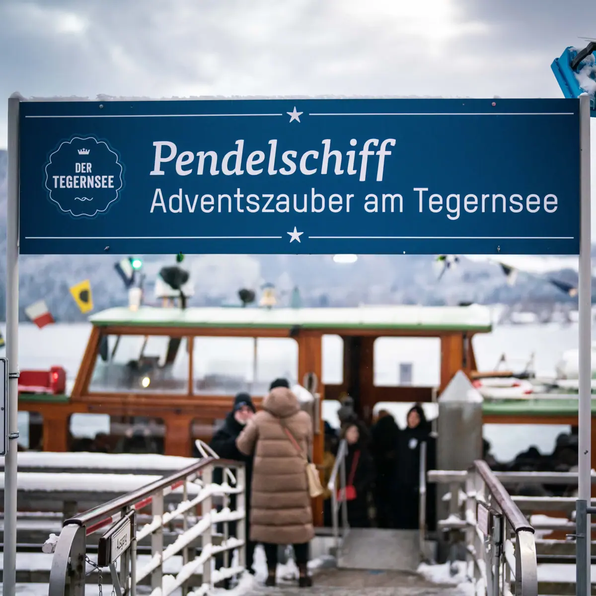 Pendelschiff Tegernsee Ein Schild auf einem Steg im Freien.