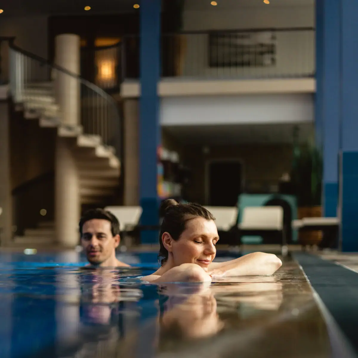 Innenpool im A-ROSA Travemünde Ein Mann und eine Frau in einem Schwimmbecken.