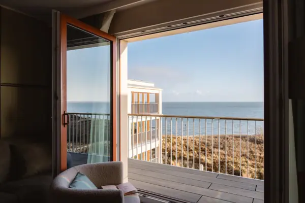 A-ROSA Sylt Ausblick Urlaub am Wattenmeer mit Blick aus einem Hotelzimmer vom A-ROSA Sylt mit Dünen und der Nordsee.