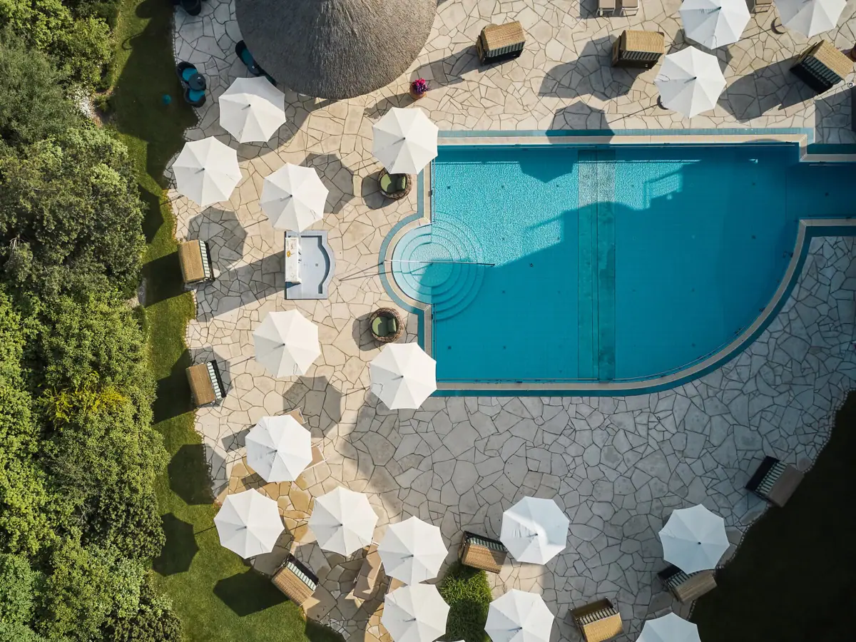 Ein Schwimmbecken mit Sonnenschirmen und Liegestühlen.