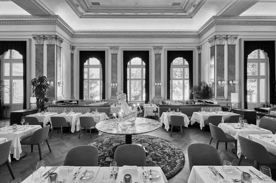 Saal im A-ROSA Straubinger Grand Hotel Bad Gastein Ein Restaurant mit Tischen und Stühlen.