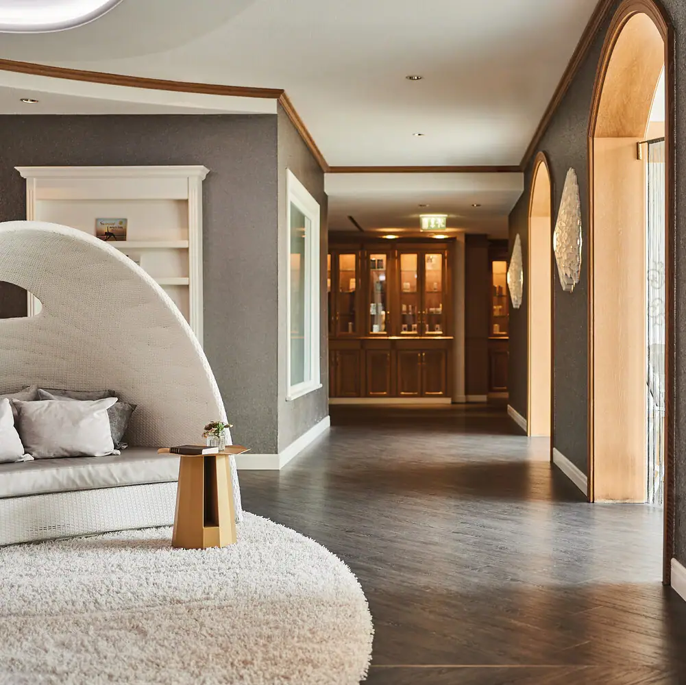 Wellness im A-ROSA Kurhaus Binz Flur mit weißem Teppich und weißem Sofa