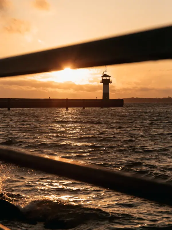 Travemünde Das Molefeuer in Travemünde bei Sonnenaufgang mit der Ostsee.