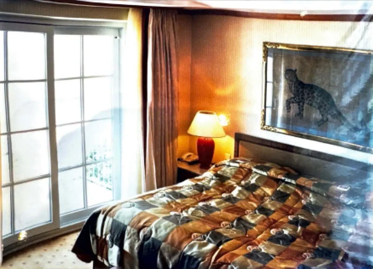 Ein Bett mit einer Lampe und einem Bild an der Wand.