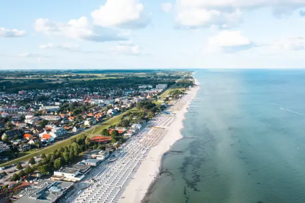Ostsee Roadtrip Strand mit Gebäuden und Wasserfläche im Hintergrund