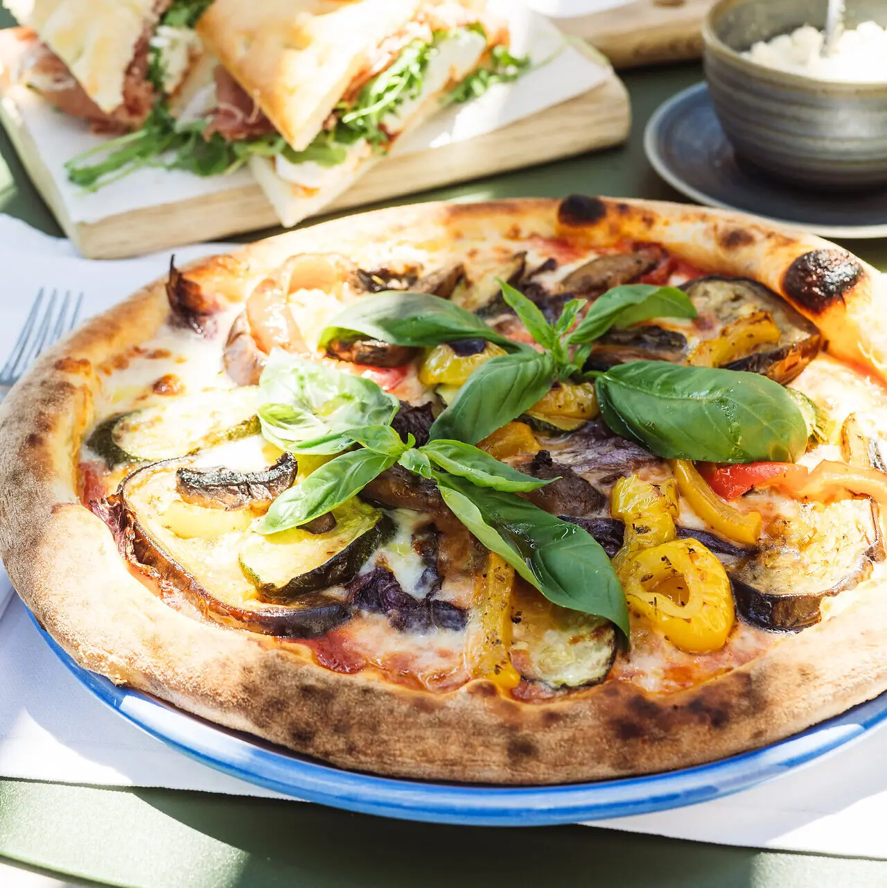 Pizzarezept italienisch Pizza mit Gemüse und Basilikum auf einem Tisch