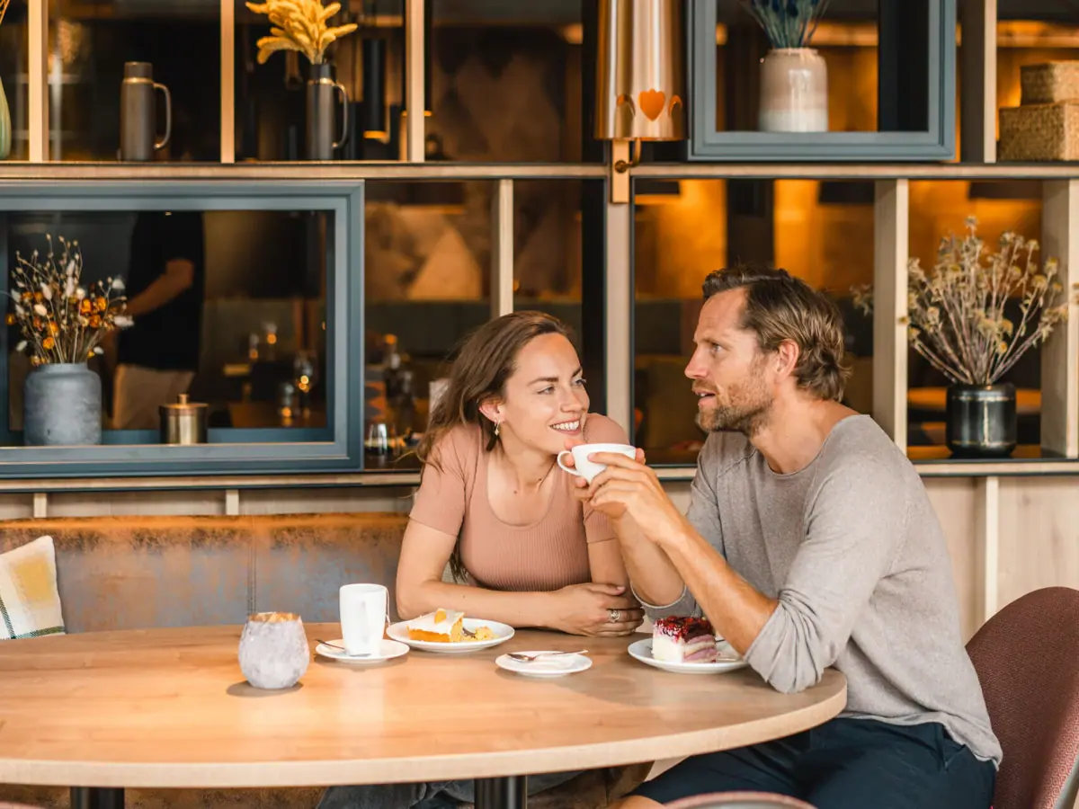Kuchenstunde im aja Hotel Ein Mann und eine Frau sitzen an einem Tisch mit Essen im aja Garmisch-Partenkirchen.