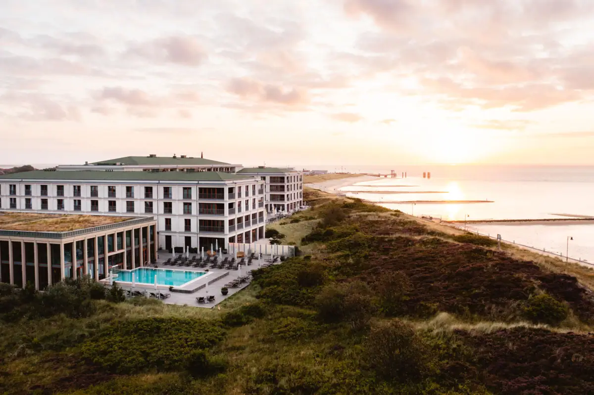 A-ROSA Sylt Das A-ROSA Sylt mit Pool direkt an den Dünen gelegen mit dem Strand und der Nordsee daneben.