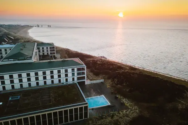A-ROSA Sylt Urlaub Am Wattenmeer im A-ROSA Hotel Sylt neben einem Strand bei Sonnenaufgang.
