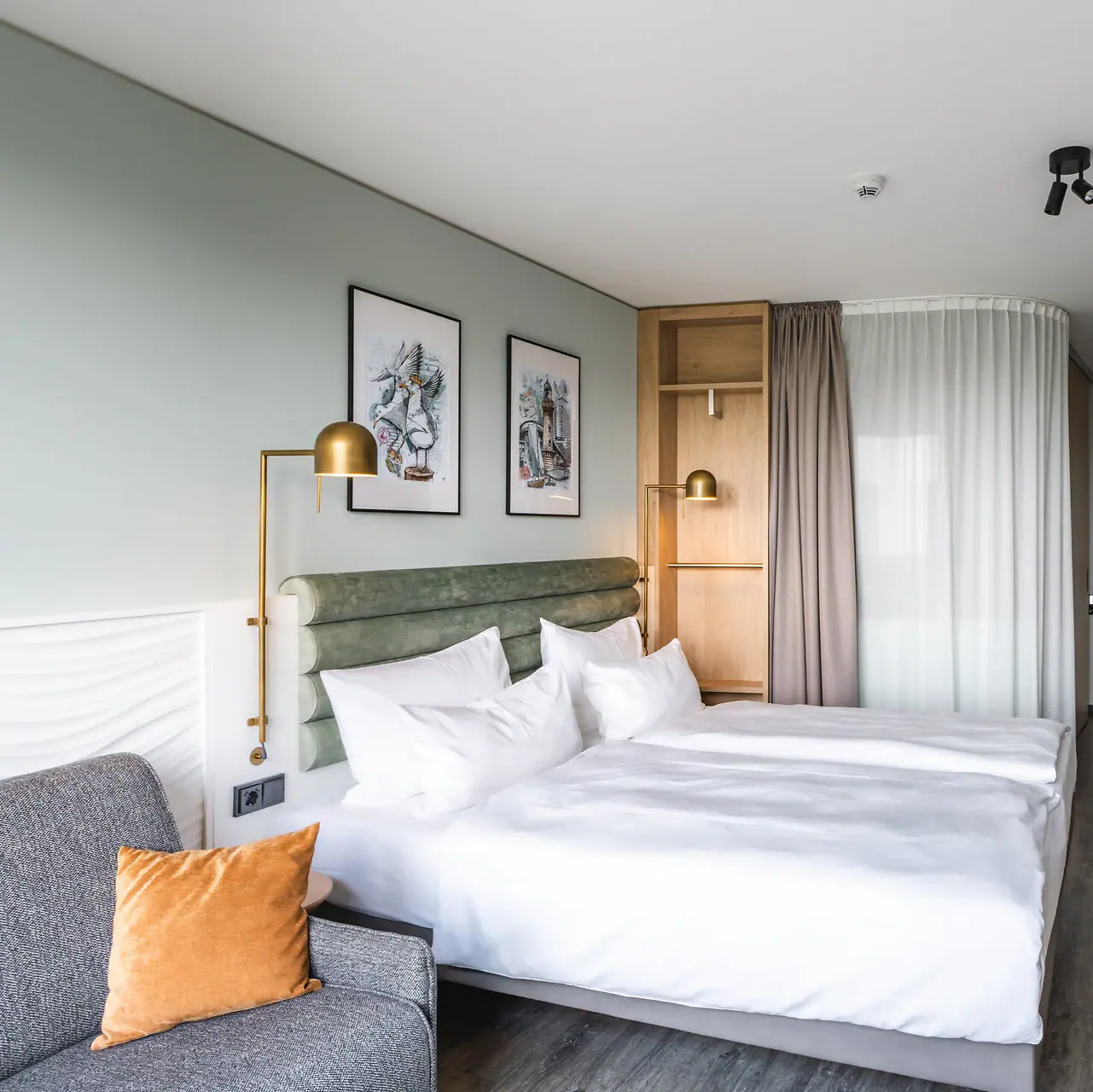 Zimmer im aja Warnemünde Hotelzimmer mit zwei Betten, Kissen und Bettwäsche.