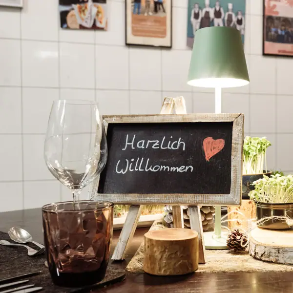 Küchentisch Kleines Schild auf dem Harzlich Willkommen steht auf dem Küchentisch im A-ROSA Gothischen Haus Wernigerode.