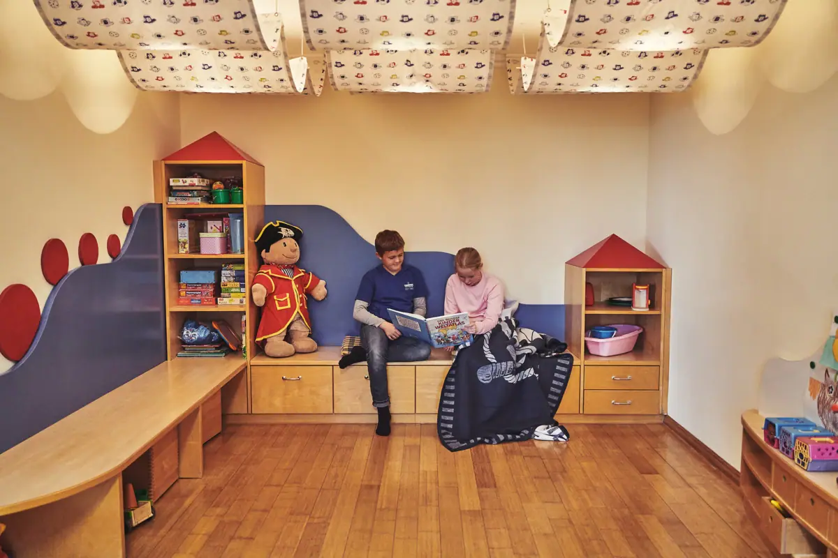 Ein Junge und ein Mädchen sitzen auf einer Bank und lesen ein Buch.